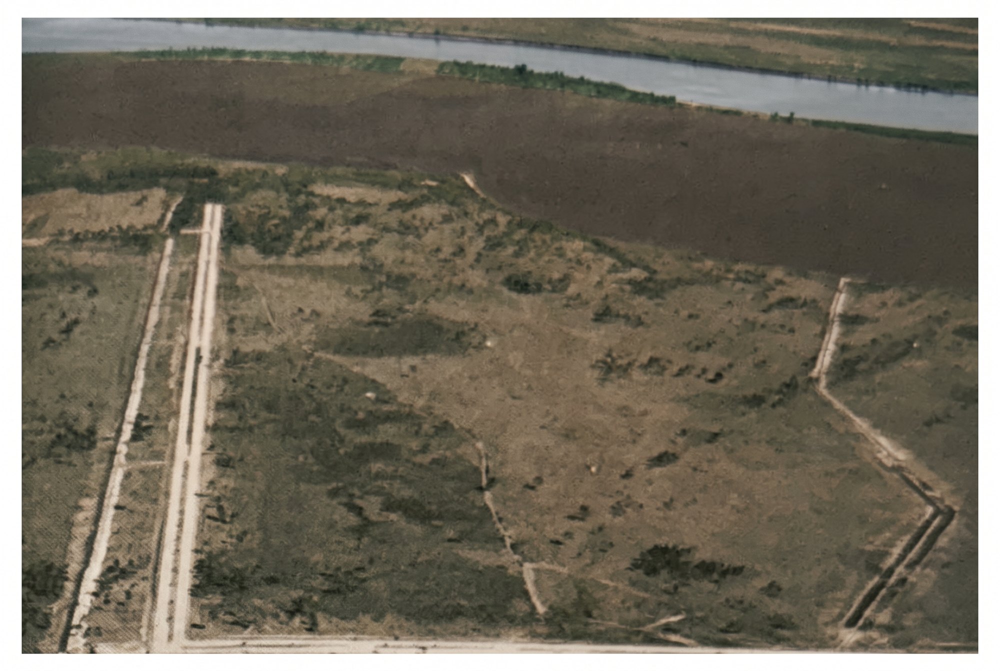 Colorized 1958 aerial of cleared scrubland and the first cut roads at Cape Coral